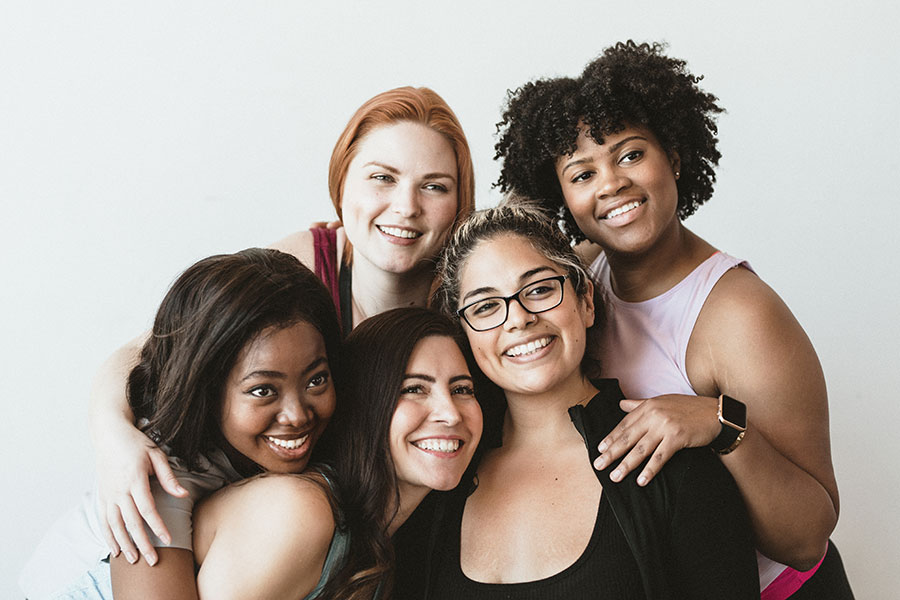 Group of diverse women smiling and hugging